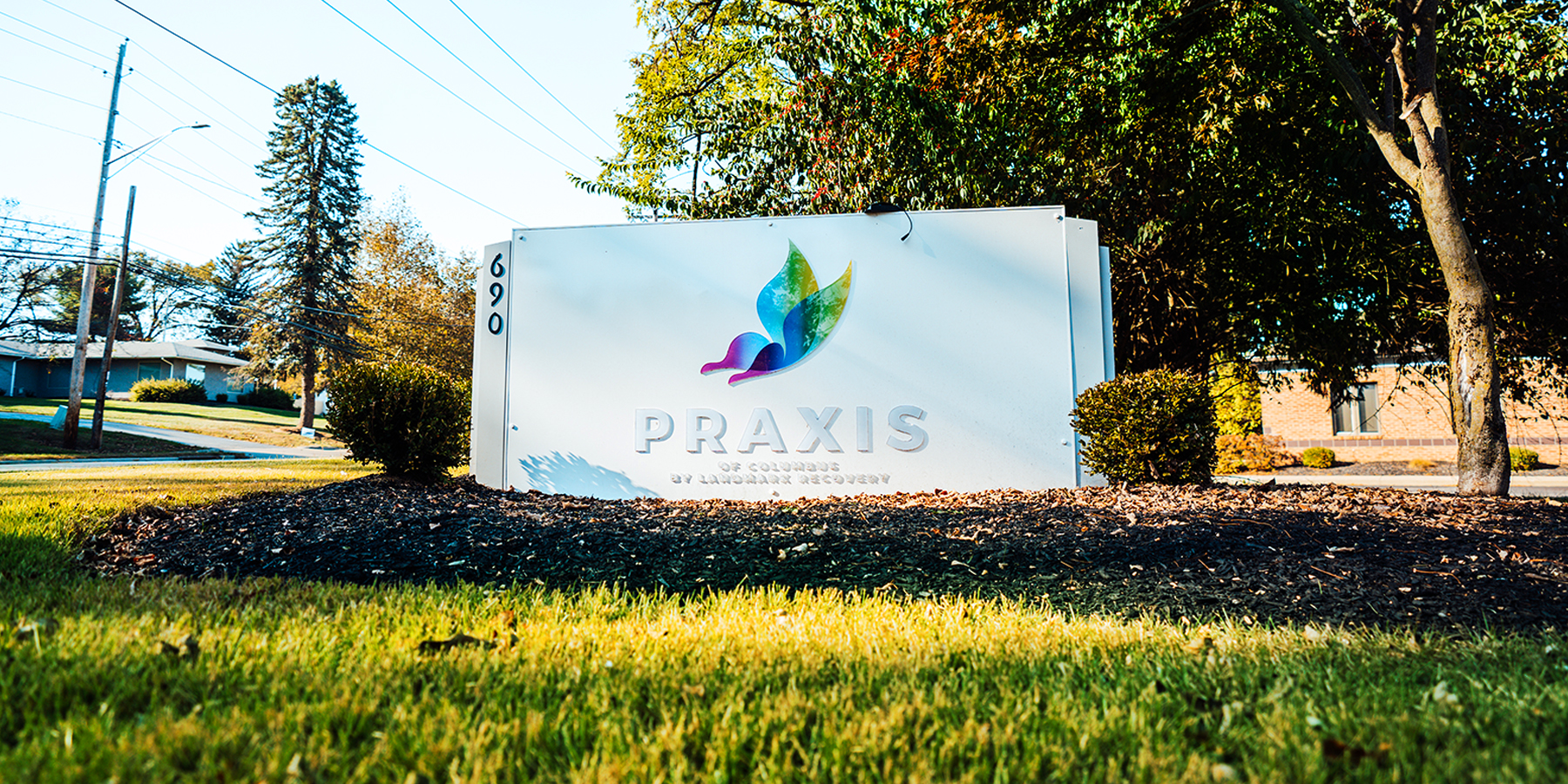 Business sign in front of Praxis of Columbus by Landmark Recovery.